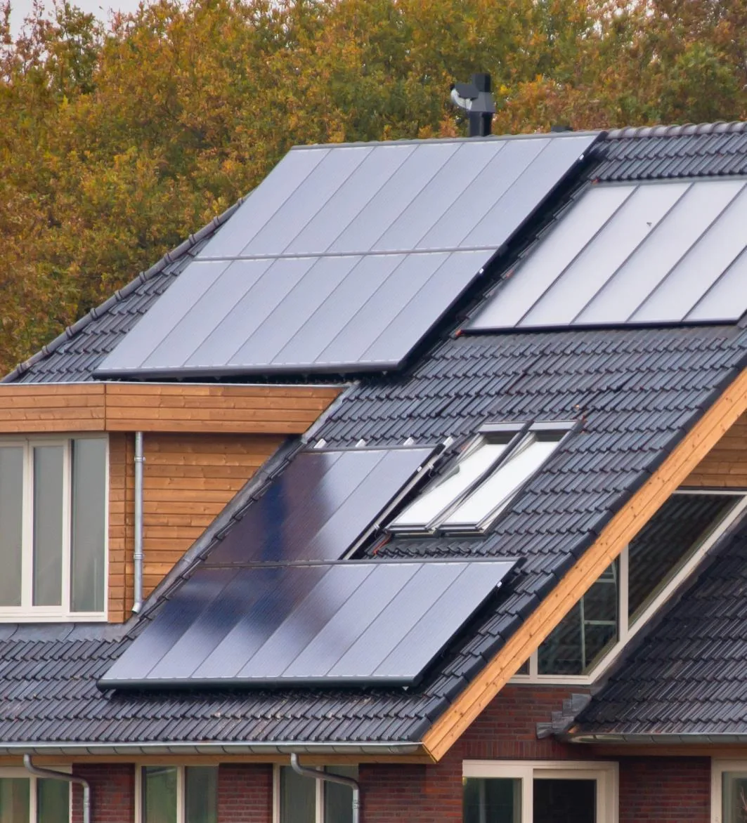 Satteldach eines Einfamilienhauses mit Photovoltaikmodulen und Dachfenstern